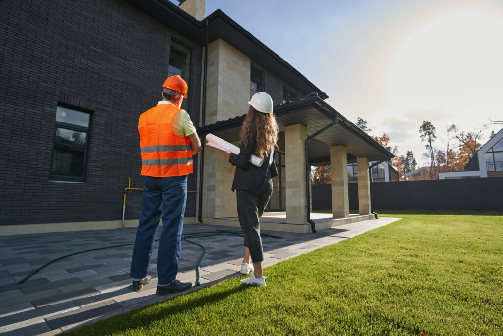 Construction professionals discussing plans outside a modern building.