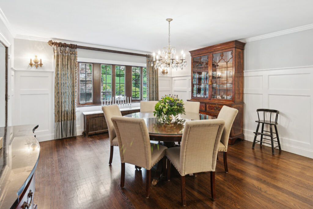 Elegant dining room with chandelier and wooden furniture.