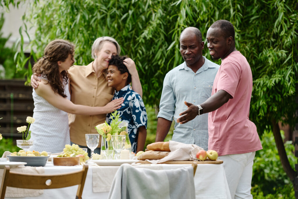 Four adults enjoying an outdoor meal with laughter and conversation.