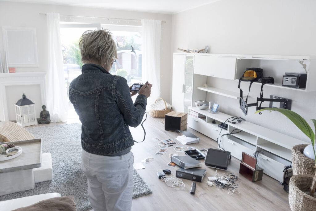 Person inspecting a camera in a cluttered living room.