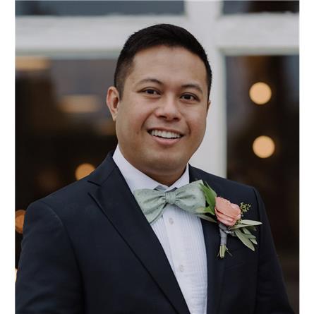Man in a tuxedo smiling at a formal event.