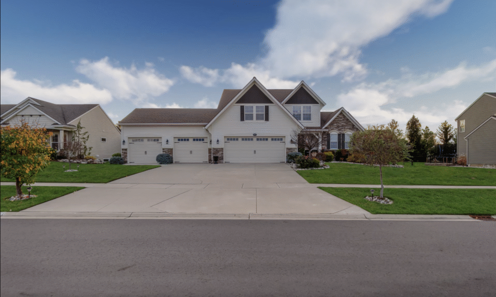 A modern suburban house with a three-car garage and a well-maintained front yard.