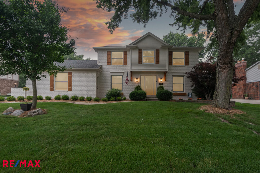 Elegant two-story suburban home at sunset with a well-manicured lawn.