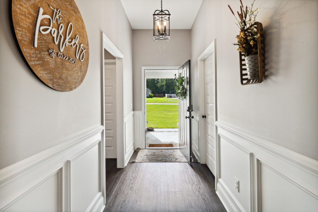 Bright hallway with open door leading to lush green yard.