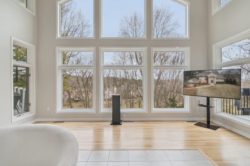 Modern living room with a large window overlooking a garden.