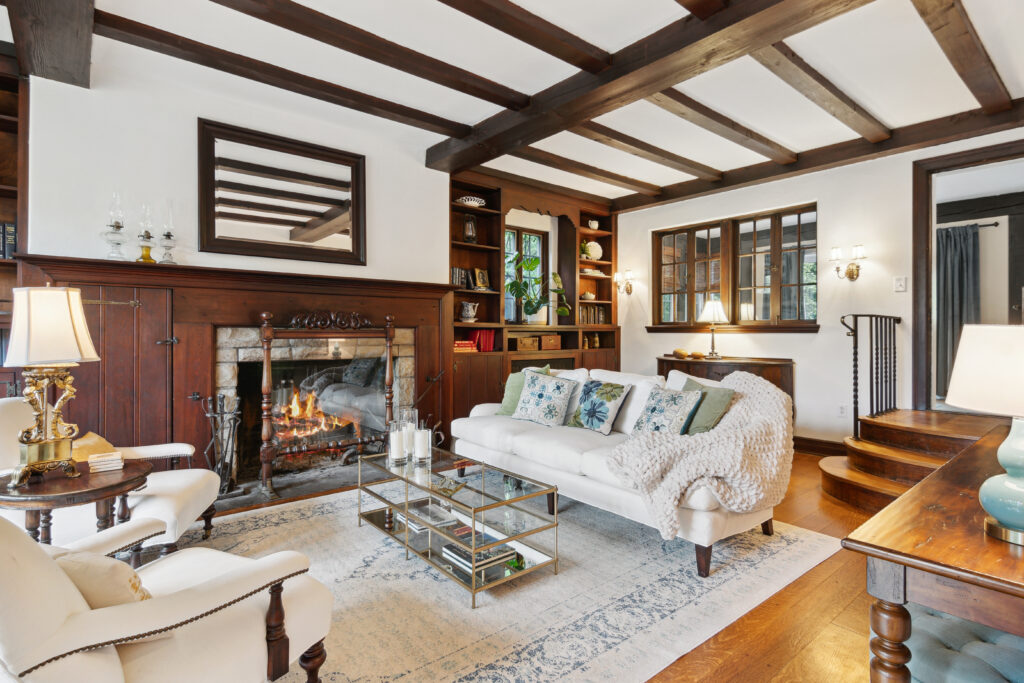 Cozy living room with wooden beams, a fireplace, and comfortable seating.