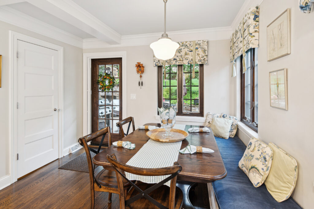 Elegant dining room with wooden table and cozy window seating.