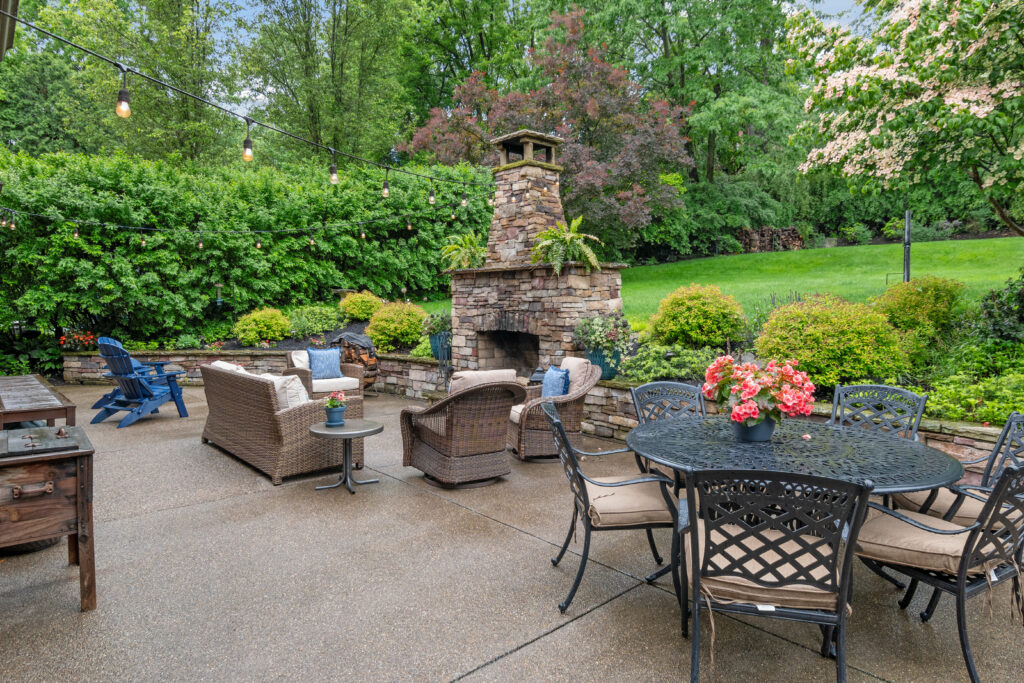Cozy outdoor patio with stone fireplace and comfortable seating.